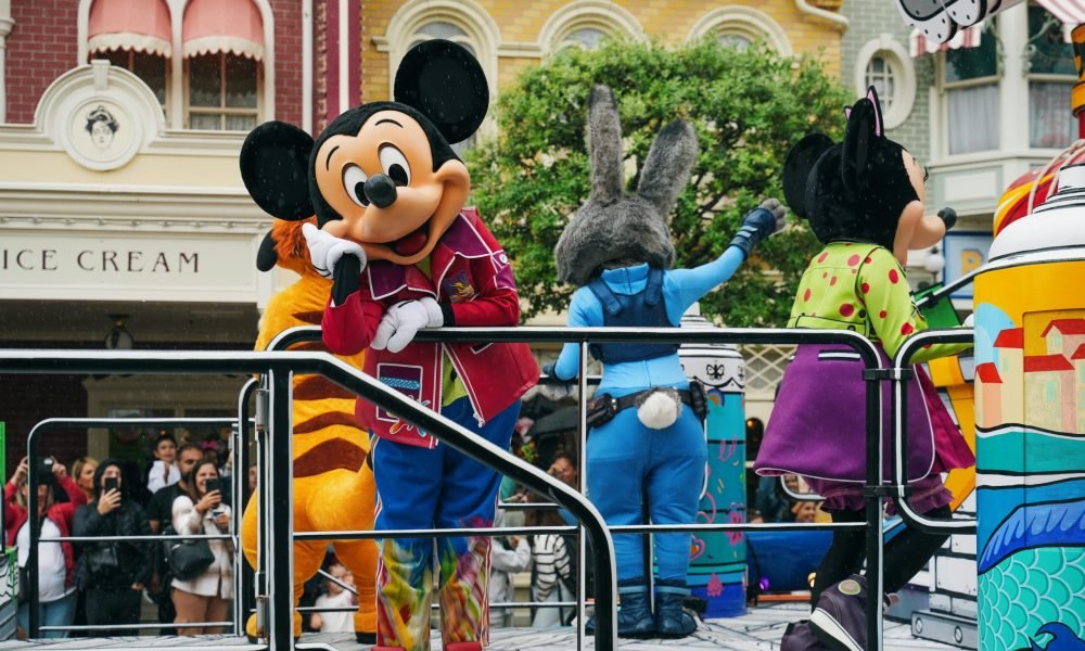 Vibrant Disneyland Paris parade with iconic Disney mascot characters entertaining the crowd.